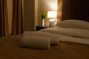 a bedroom with a large white bed with a lamp at Hotel Tiflida in Tbilisi City