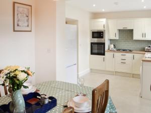 a kitchen with a table with a vase of flowers at Number 23 in Wooler