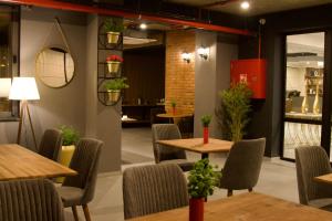 a restaurant with tables and chairs and plants at Hotel Tiflida in Tbilisi City