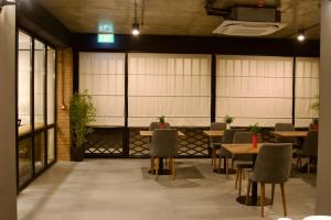 a dining room with tables and chairs and windows at Hotel Tiflida in Tbilisi City