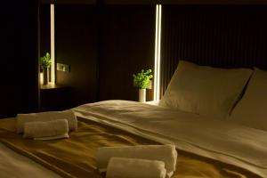 a bed in a dark room with two towels on it at Hotel Tiflida in Tbilisi City