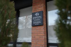 a sign on a brick pillar in front of a window at Hotel Tiflida in Tbilisi City +52 photos