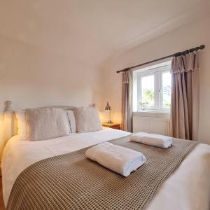 a bedroom with a large bed with two towels on it at Chy Bownder Cottage in Lostwithiel
