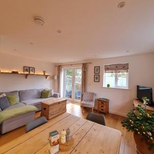 a living room with a couch and a table at Chy Bownder Cottage in Lostwithiel