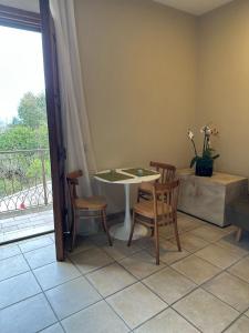 a table and chairs in a room with a balcony at Anticoleum Room in Caiazzo +4 photos
