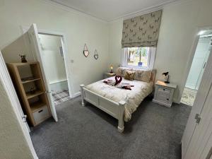 a bedroom with a bed and a window and a mirror at The Sandbed Retreat in Hawick