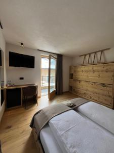 a bedroom with a large bed and a desk at Gran Zebrú B&B - high mountain in Valfurva