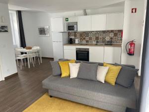 a living room with a couch and a kitchen at A Casinha in Angra do Heroísmo