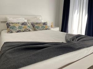 a bed with a black blanket and pillows on it at A Casinha in Angra do Heroísmo
