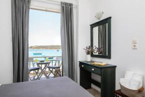 a bedroom with a bed and a view of the ocean at Angeliki Seaside Hotel in Aliki
