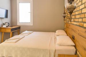 a bedroom with two beds and a brick wall at Ballı Butik hotel in Kayakoy +47 photos