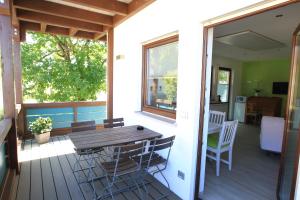 een veranda met een houten tafel en stoelen op een terras bij Messewohnung Rehdorf in Oberasbach