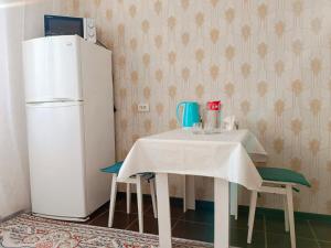 a kitchen with a table and a refrigerator at 11 Microragion in Aktobe +5 photos