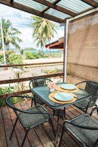 a table and chairs on a deck with a view of the beach at Matira Tiny house 3 in Bora Bora