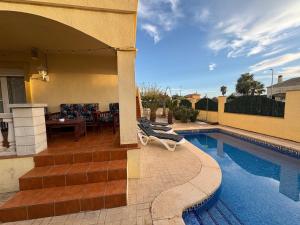a house with a swimming pool and a patio at Casa Campanilla in Riumar