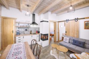 a kitchen and a living room with a couch and a table at Chaty Čučoriedky in Žiar