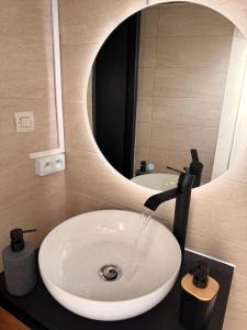 a bathroom sink with water coming out of it at Titi90 in Belfort +11 photos