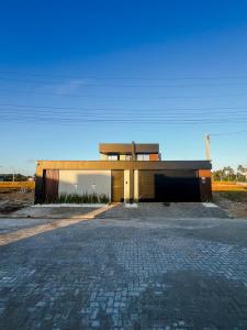 a large building with a driveway in front of it at Casa Aconchegante em Japaratinga in Japaratinga