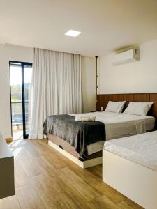 a hotel room with two beds and a window at Casa Aconchegante em Japaratinga in Japaratinga +23 photos