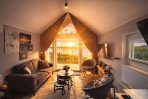 a living room with a couch and a window at Tiny Haus Auszeit am See in Lathum