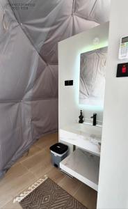 a bathroom with a sink and a mirror in a tent at Sunset domes private camp in Al Raka