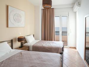 a hotel room with two beds and a balcony at Ostria View in Kardamaina