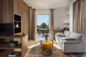 a living room with a couch and a tv at Minavra Hotel in Athens