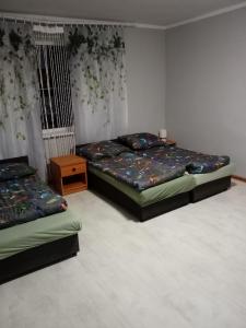 a bedroom with two beds and a night stand at Pełna Chata Trojanka in Połczyn-Zdrój