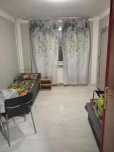 a bedroom with two beds and a window with curtains at Pełna Chata Trojanka in Połczyn-Zdrój