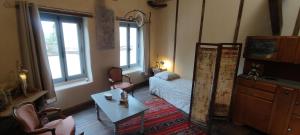 a living room with a bed and a table at L'Escalier des Rêves - Rose in Saint-Sauveur-en-Puisaye