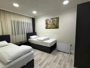 a room with two beds and a painting on the wall at Hevsel hotel in Diyarbakır +25 photos