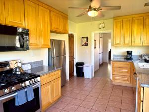 a kitchen with wooden cabinets and a stove top oven at Cozy Farm House with River access in Three Rivers