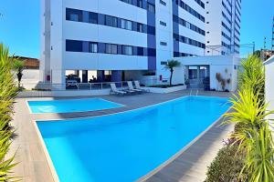 a large swimming pool in front of a building at Vacanze - Alicante in Maceió
