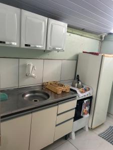 a small kitchen with a sink and a refrigerator at Kitnet Flamingo Matinhos 31B in Matinhos