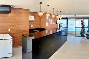 a kitchen with a black counter and wooden wall at Vacanze - Alicante in Maceió