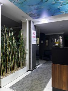 a lobby with a blue ceiling with plants on the wall at Hevsel hotel in Diyarbakır