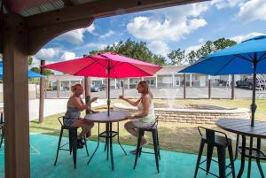two women sitting at a table with umbrellas at Liberty hill Executive Inn in Zephyrhills
