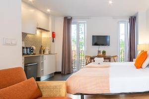 a bedroom with a large bed and a kitchen at Ourique Charm Apartments in Lisbon