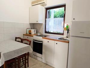 a small kitchen with a sink and a refrigerator at Apartmani Mataija in Sveti Petar