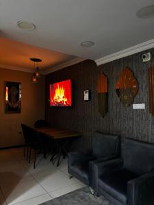 a living room with a table and a fire painting on the wall at Hevsel hotel in Diyarbakır