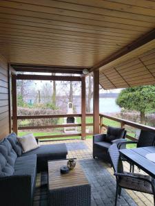 a patio with couches and a table and a grill at Rodzinny Domek Ruś in Ruś +9 photos