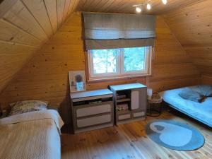 a room with two beds and a window in a cabin at Rodzinny Domek Ruś in Ruś