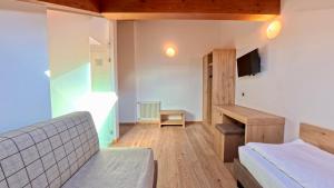 a bedroom with a bed and a desk and a tv at Hotel Cristallo in Canazei