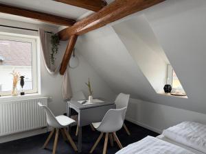 a bedroom with a desk and two chairs and a bed at Royans Ferienwohnung in Günzburg