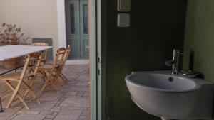 a bathroom with a sink and a table with chairs at Symi Village House in Symi +46 photos