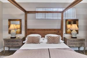 a bedroom with a large bed with two mirrors at Frnch on 2nd - Sandton in Johannesburg