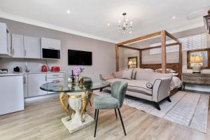 a kitchen and living room with a table and a bed at Frnch on 2nd - Sandton in Johannesburg