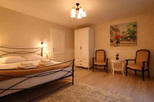 a bedroom with a bed and two chairs and a table at Zodia Craiului in Peştera