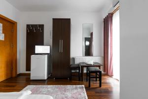 a room with a refrigerator and a table with chairs at Hotel VULTURUL Pitesti in Piteşti