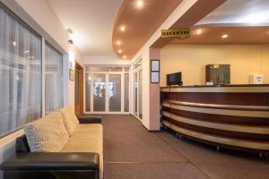 a waiting room with a couch and a bar at Hotel VULTURUL Pitesti in Piteşti